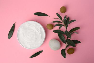 Photo of Natural cosmetic. Olive cream, pebble stone and ingredient on pink background, flat lay