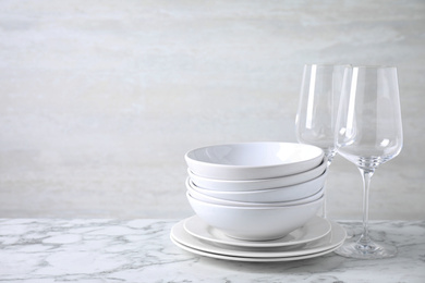 Photo of Set of clean dishware on marble table. Space for text