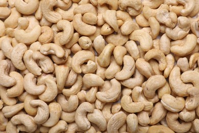 Photo of Many tasty cashew nuts as background, top view