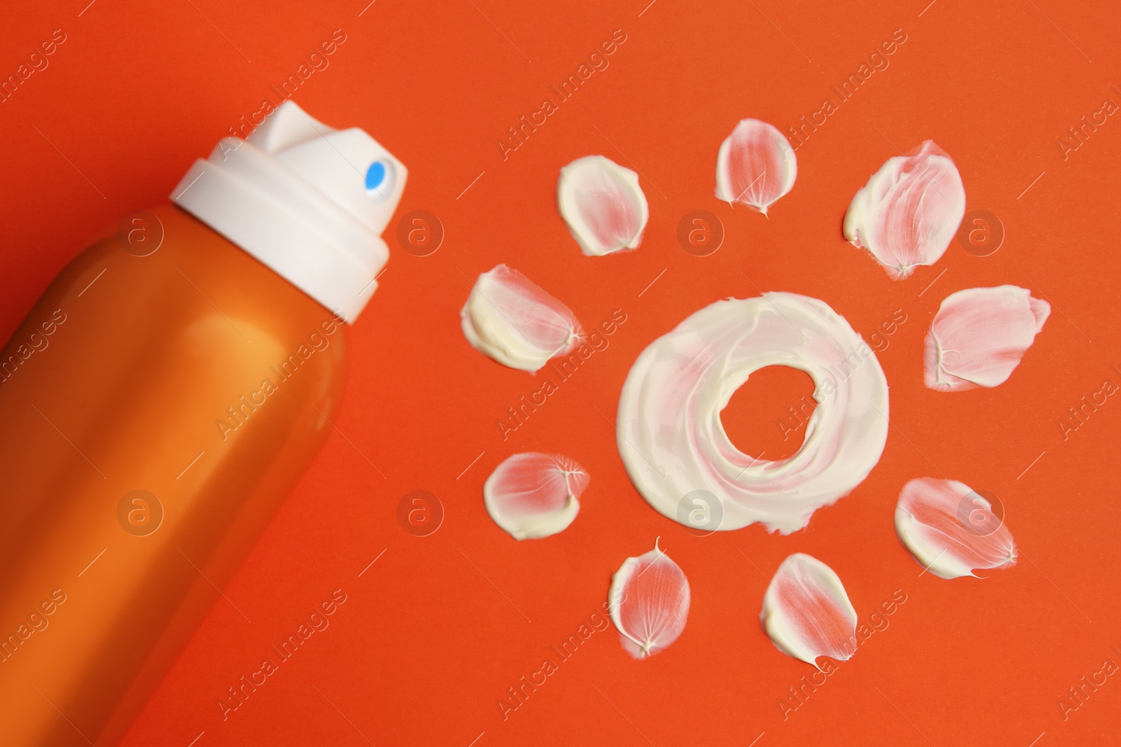 Photo of Drawing of sun and bottle with sunscreen on coral background, top view. Skin protection