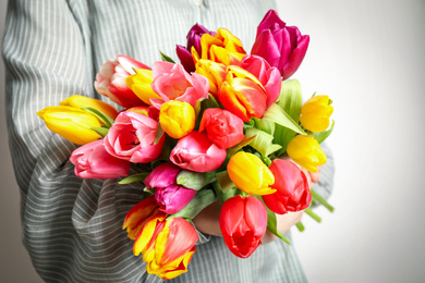 Photo of Woman holding beautiful spring tulips on white background, closeup