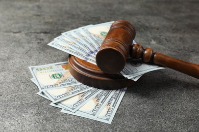 Photo of Judge's gavel and money on grey table