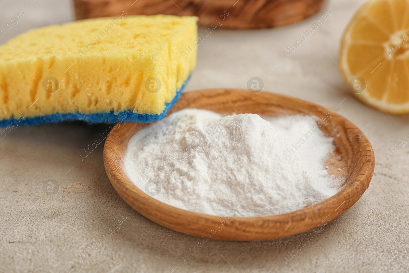 Photo of Bowl with baking soda and sponge on gray table