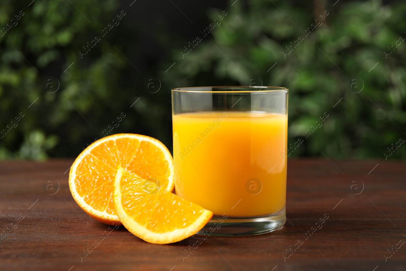 Photo of Glass of orange juice and fresh fruits on wooden table