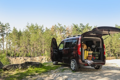 Van with camping equipment in trunk outdoors