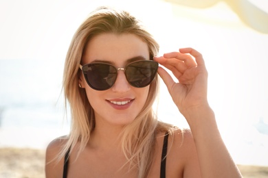 Beautiful woman wearing sunglasses outdoors on sunny day