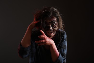 Photo of Scary zombie on dark background. Halloween monster