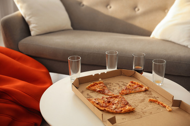 Photo of Tasty fresh pizza on light table in living room