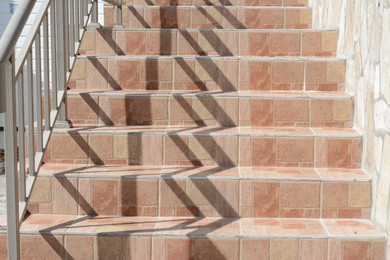Photo of Beautiful tiled stairs with metal railings outdoors
