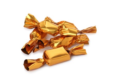 Photo of Delicious candies in golden wrappers on white background