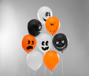Photo of Color balloons for Halloween party on light grey background