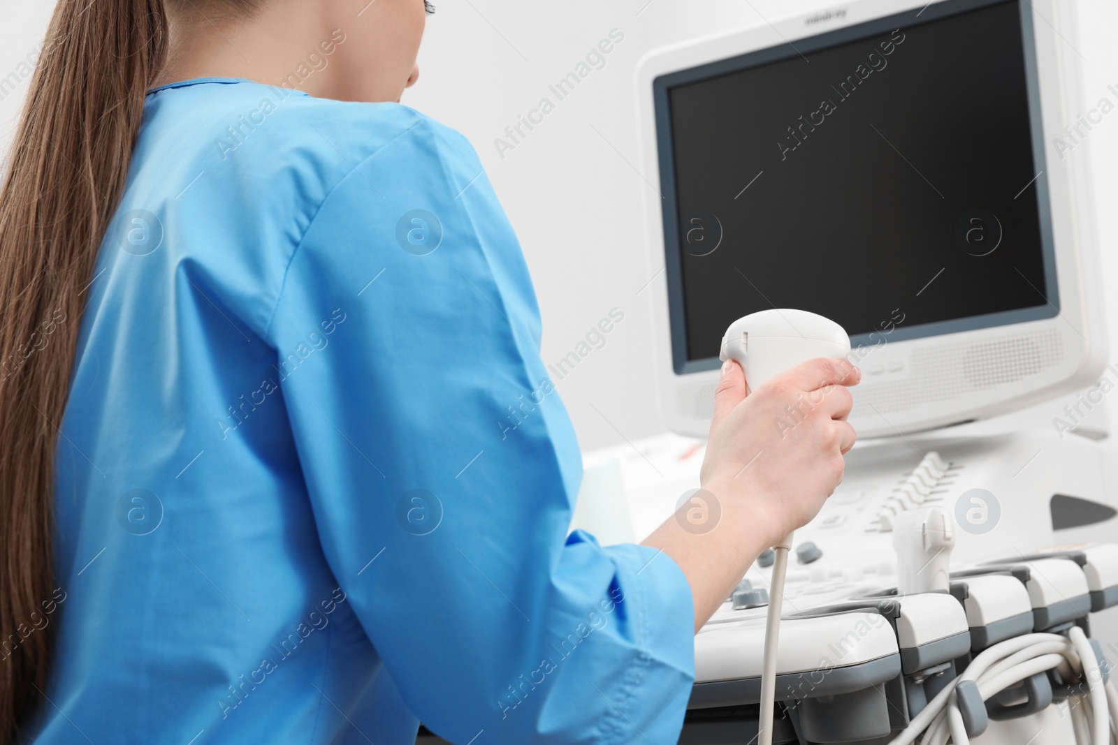 Photo of Sonographer operating modern ultrasound machine in clinic, closeup