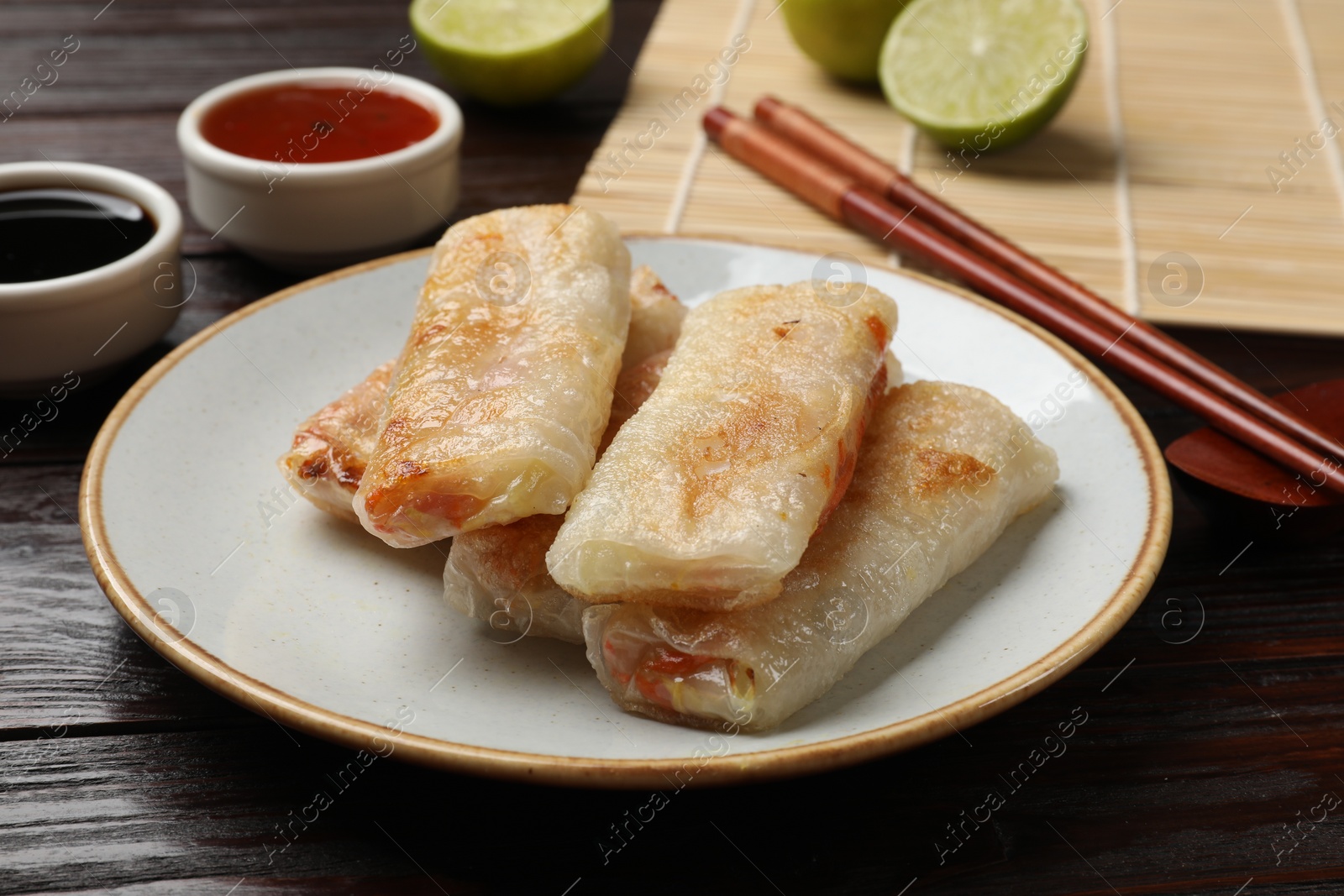 Photo of Delicious fried spring rolls served on wooden table