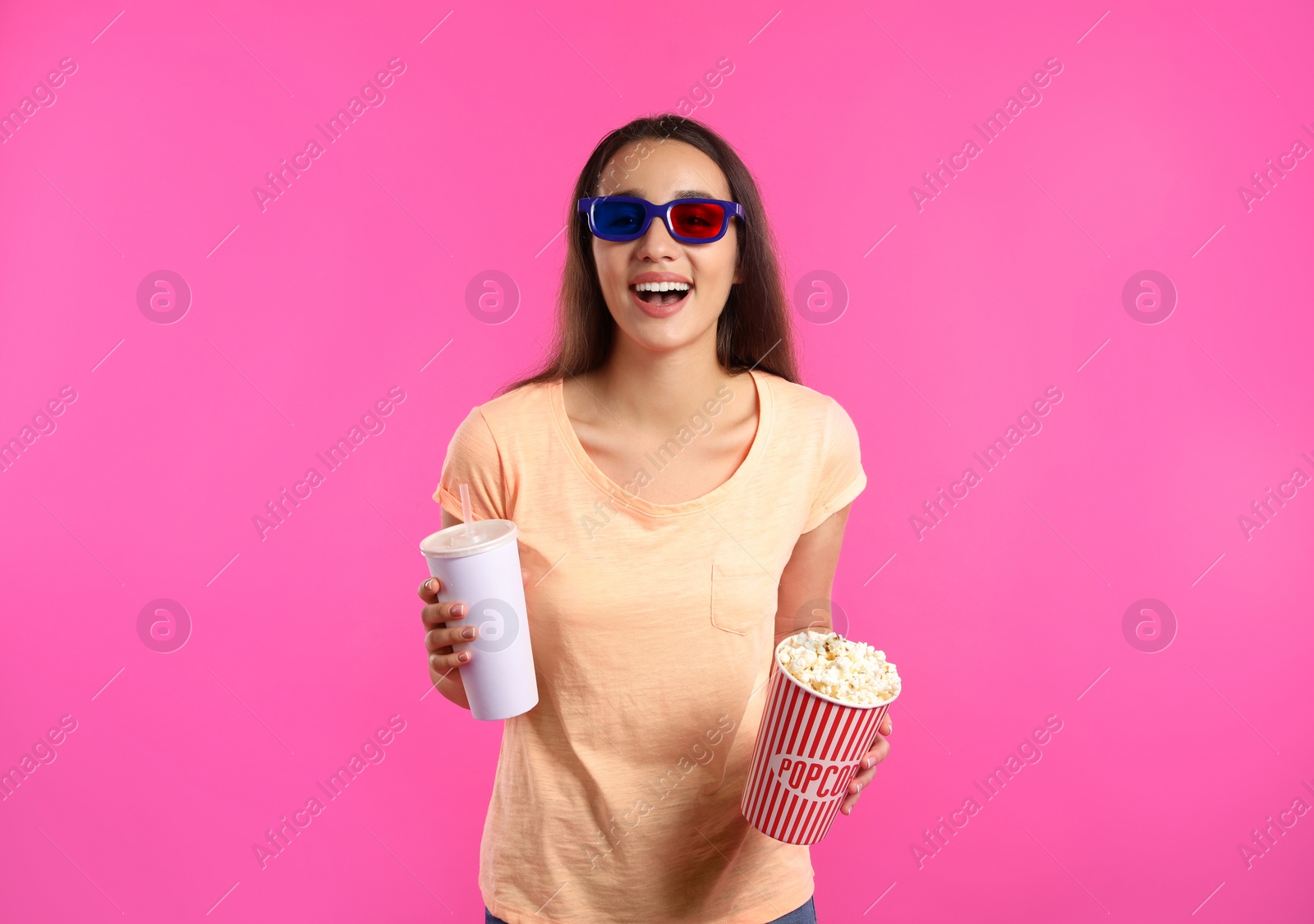 Photo of Woman with 3D glasses, popcorn and beverage during cinema show on color background