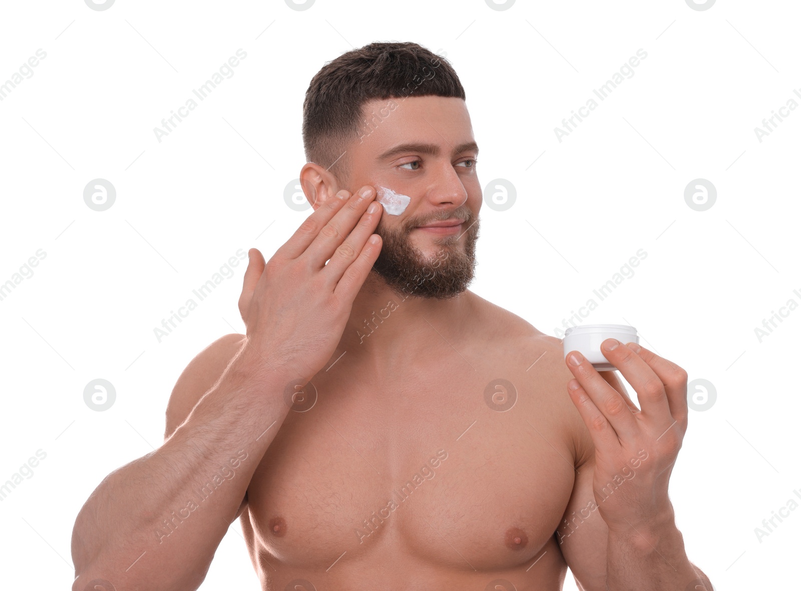 Photo of Handsome man applying cream onto his face on white background