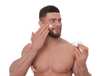 Handsome man applying cream onto his face on white background