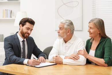 Notary consulting senior couple about Last Will and Testament in office