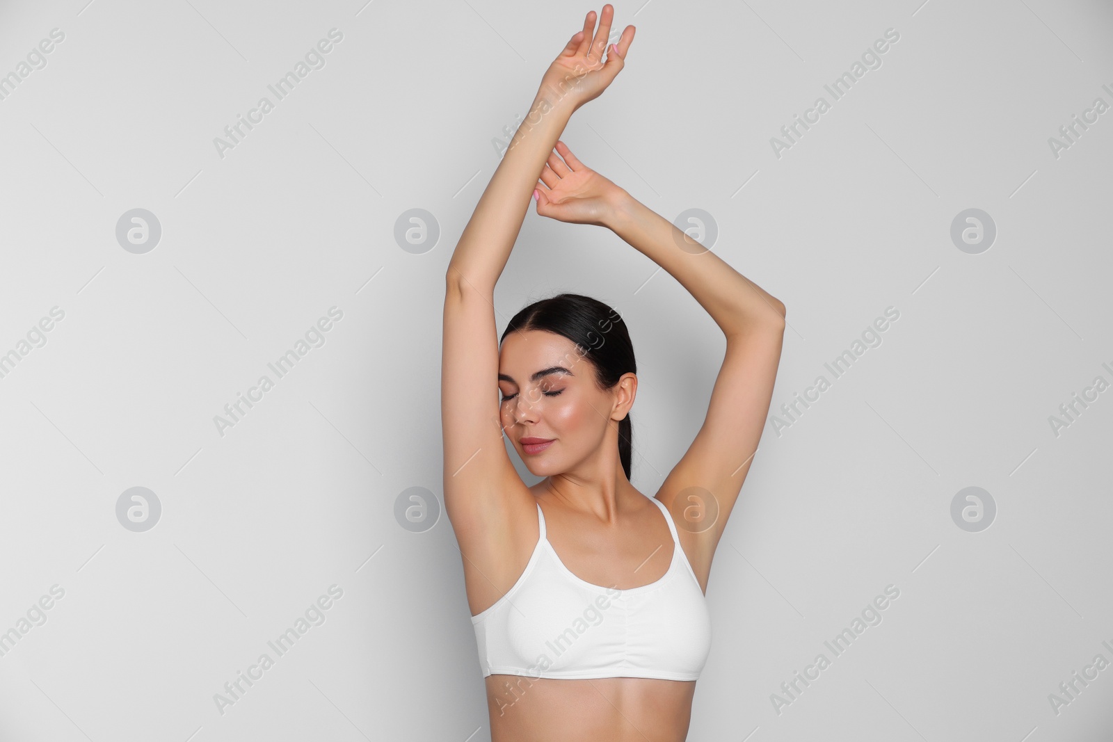 Photo of Young woman showing smooth skin after epilation on white background