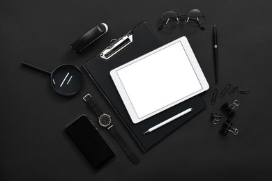 Flat lay composition with modern tablet on black background. Space for text