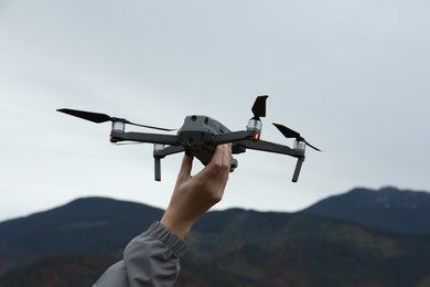 Woman with modern drone in mountains, closeup