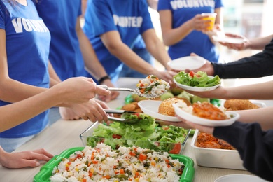 Photo of Volunteers serving food to poor people, closeup