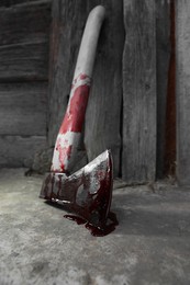 Photo of Axe with blood on floor indoors, closeup
