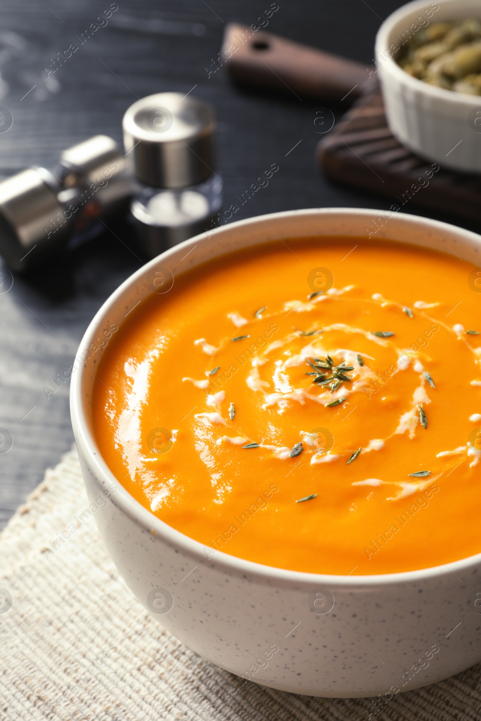 Photo of Delicious pumpkin cream soup in bowl on table