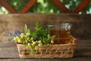 Photo of Tasty herbal tea, fresh lavender flowers and linden branches on wooden table