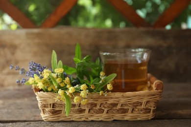 Tasty herbal tea, fresh lavender flowers and linden branches on wooden table