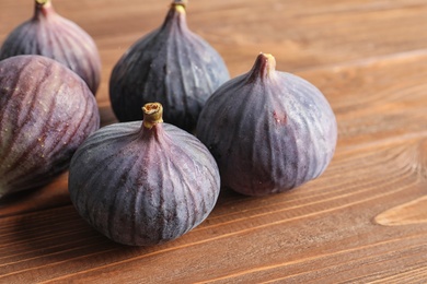 Photo of Ripe sweet figs on wooden background. Tropical fruit