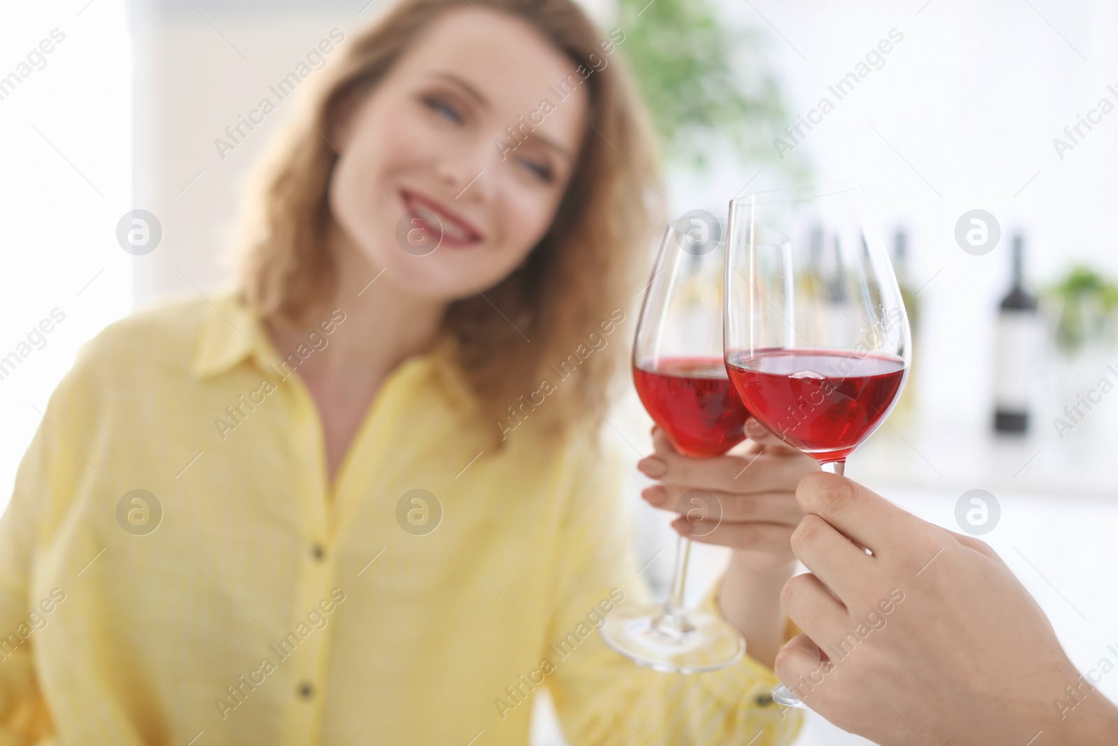 Photo of Young couple with glasses of delicious wine indoors