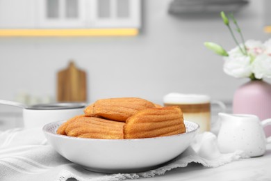 Tasty madeleine cookies on table in kitchen