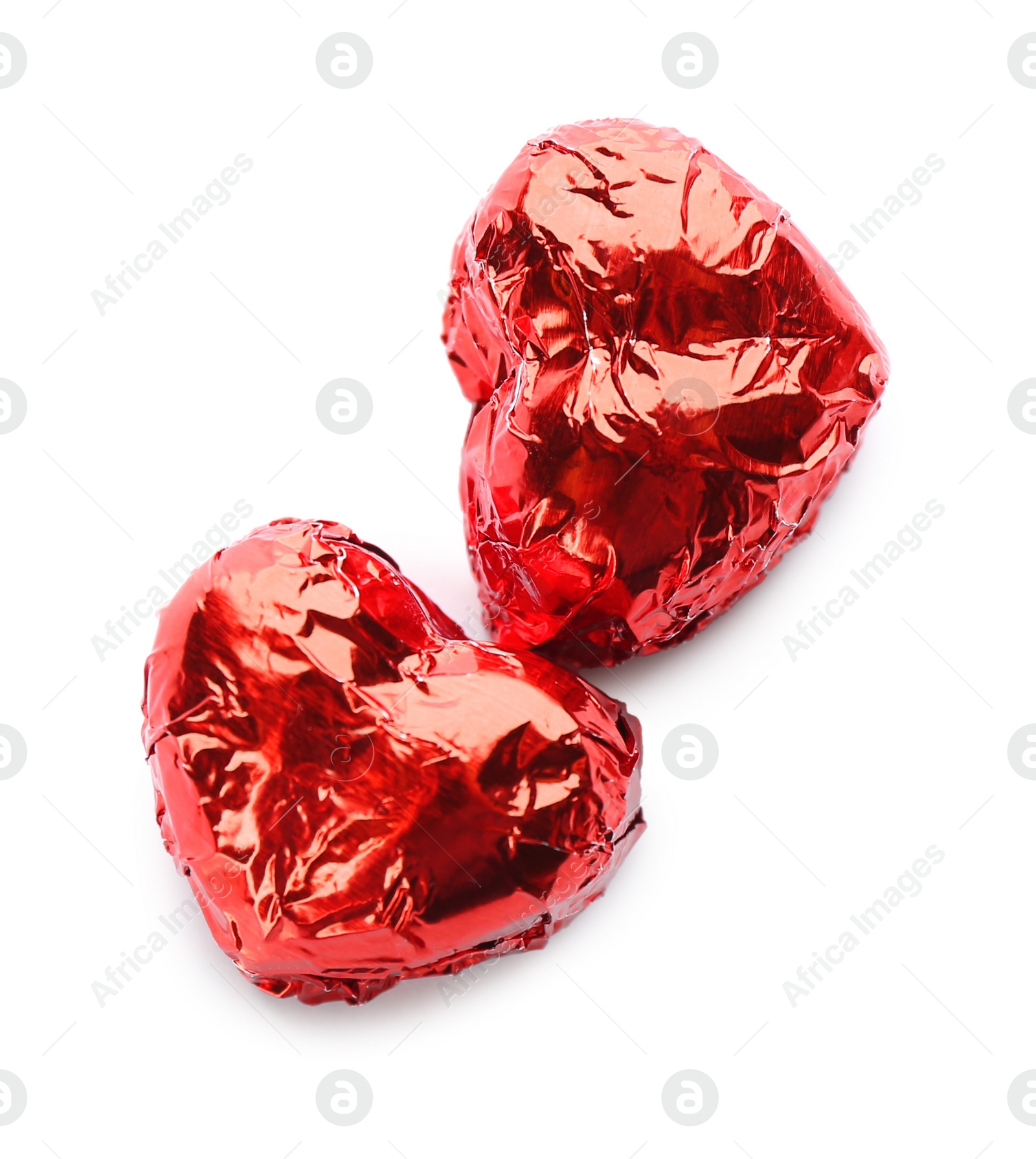 Photo of Heart shaped chocolate candies in red foil on white background, top view