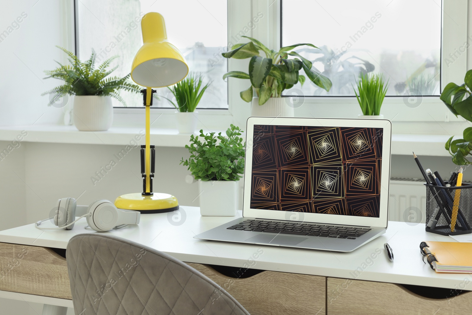 Photo of Cozy workspace with laptop on white wooden desk at home