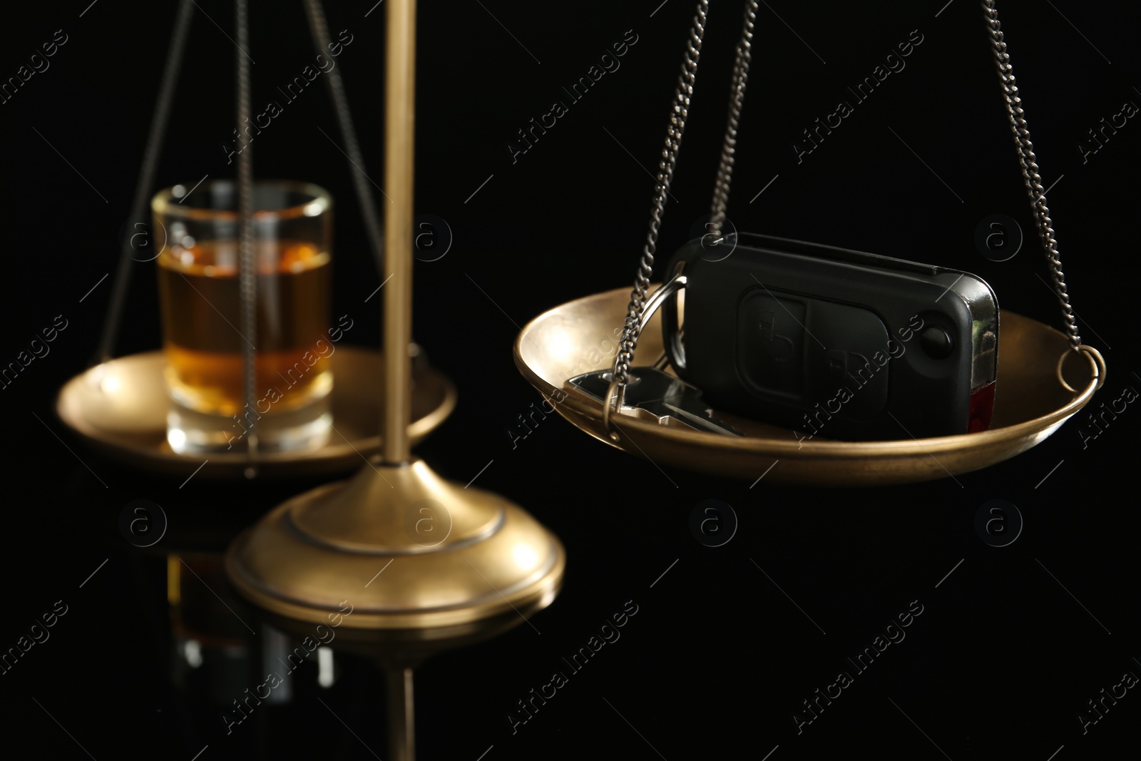 Photo of Scales of justice with car key and alcohol on black background, closeup. Drunk driving