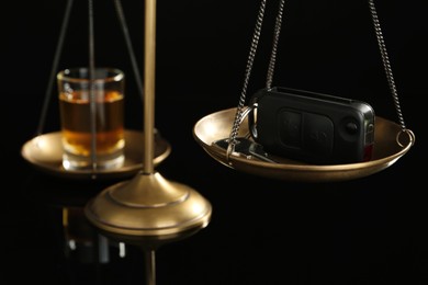 Photo of Scales of justice with car key and alcohol on black background, closeup. Drunk driving