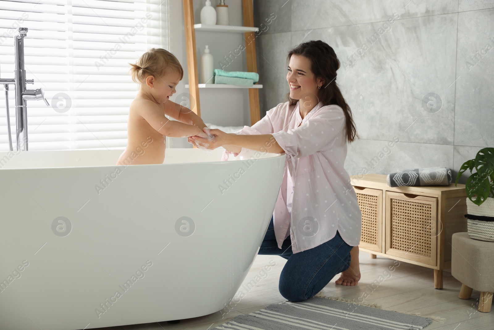 Photo of Mother with her little daughter in bathroom