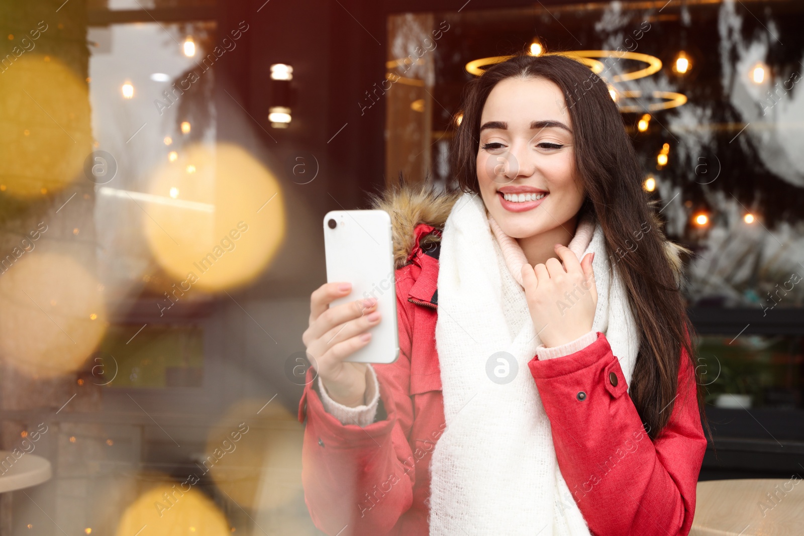 Photo of Young woman taking selfie at winter fair. Christmas celebration