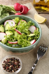 Delicious salad with radish in bowl served on table