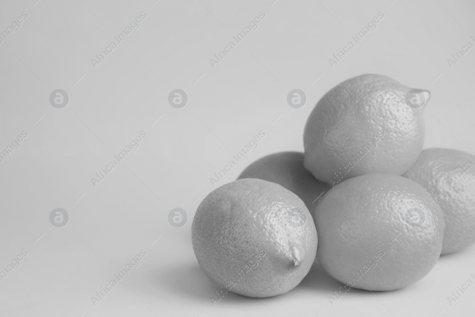 Image of Fresh ripe lemons on grey background, space for text. Black and white tone 