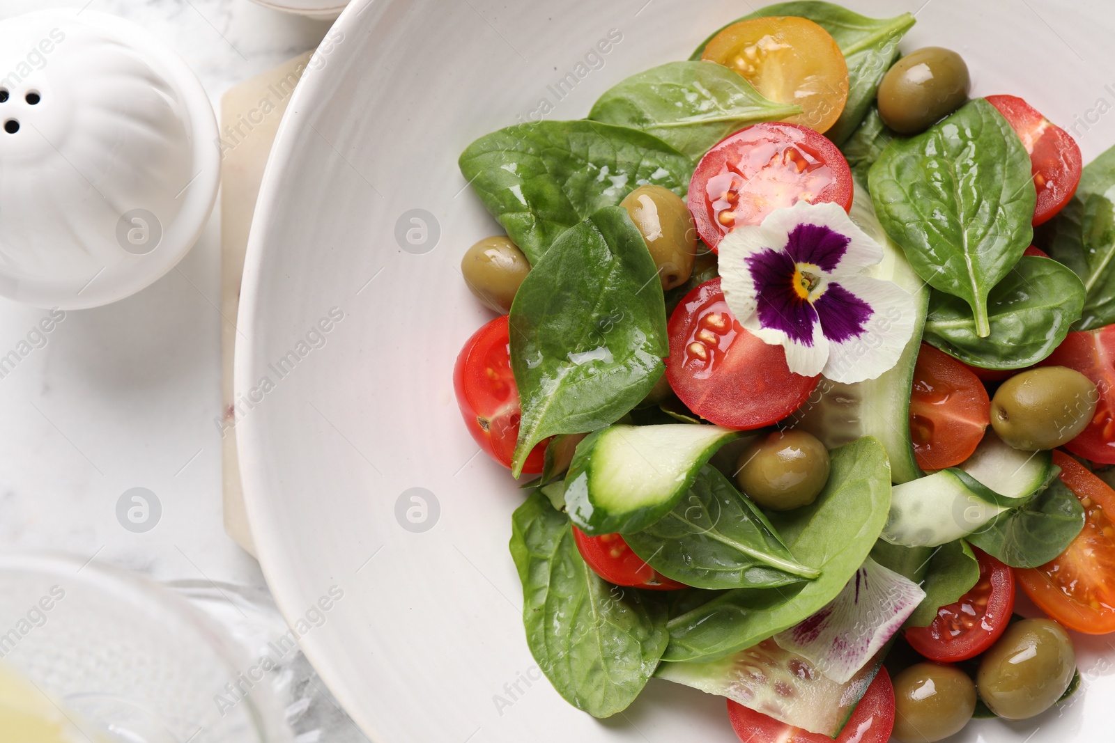 Photo of Delicious salad with vegetables and olives on white table, flat lay