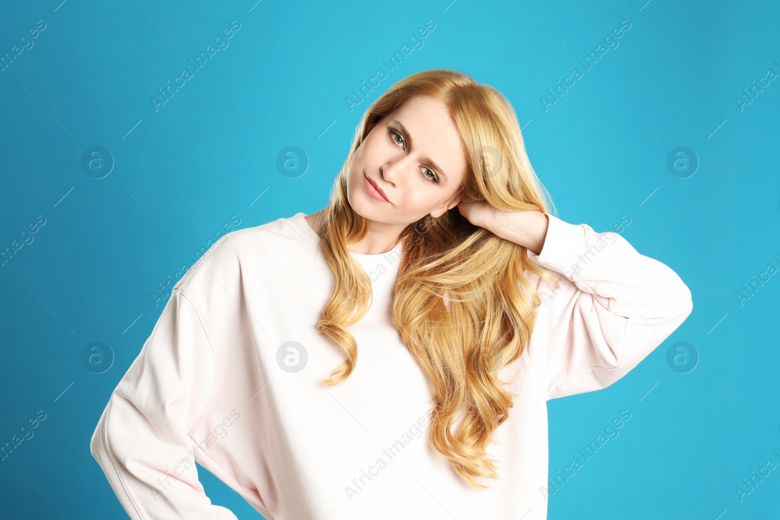 Photo of Portrait of beautiful young woman with dyed long hair on blue background