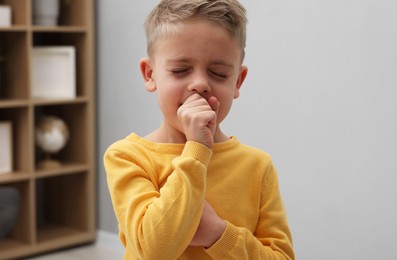 Photo of Sick boy coughing at home. Cold symptoms