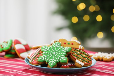 Photo of Decorated cookies on table against blurred Christmas lights