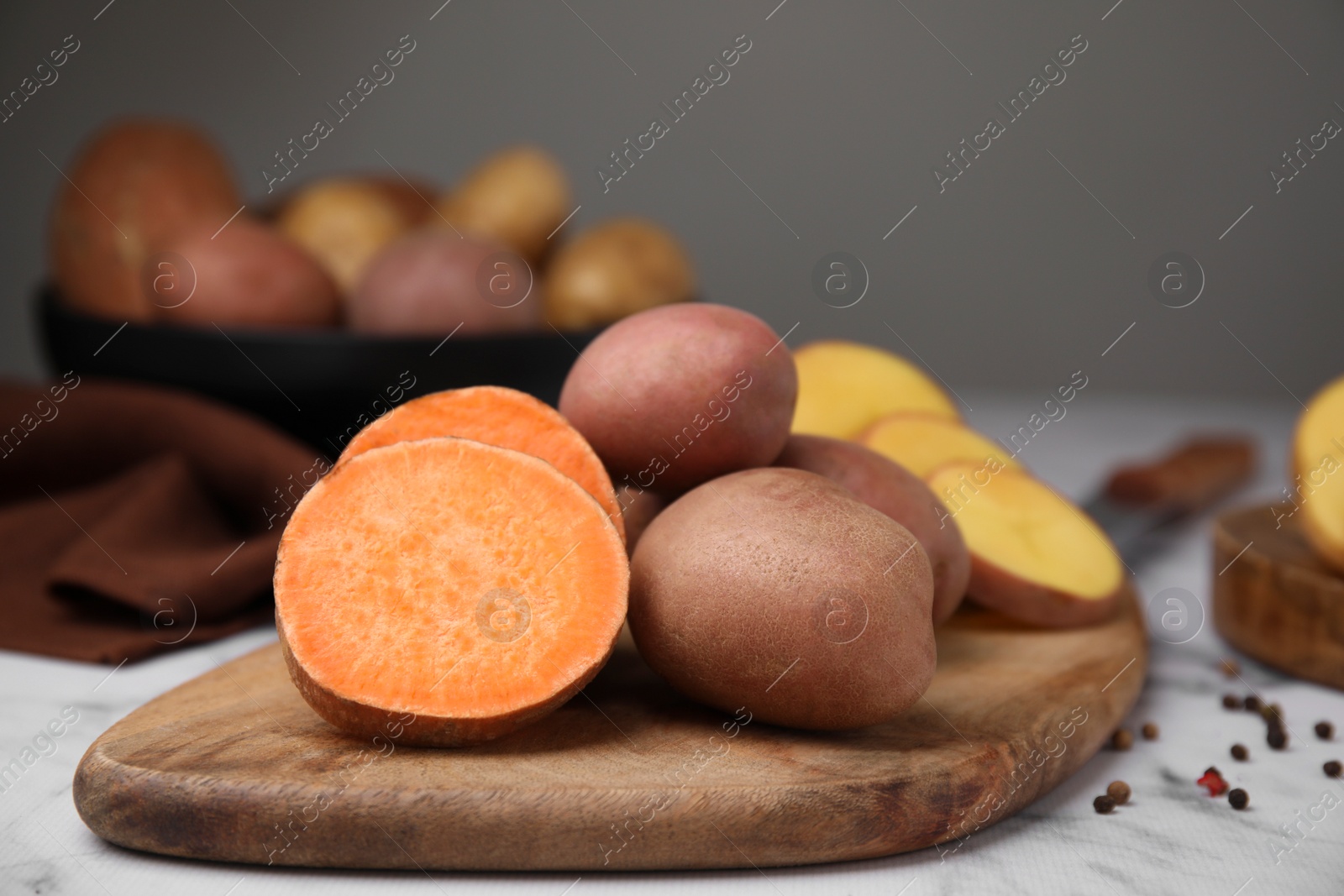 Photo of Different types of fresh potatoes on wooden board