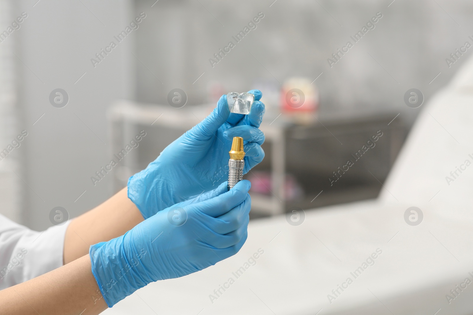 Photo of Dentist holding educational model of dental implant indoors, closeup. Space for text