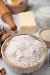 Bowl of flour and other ingredients on white table