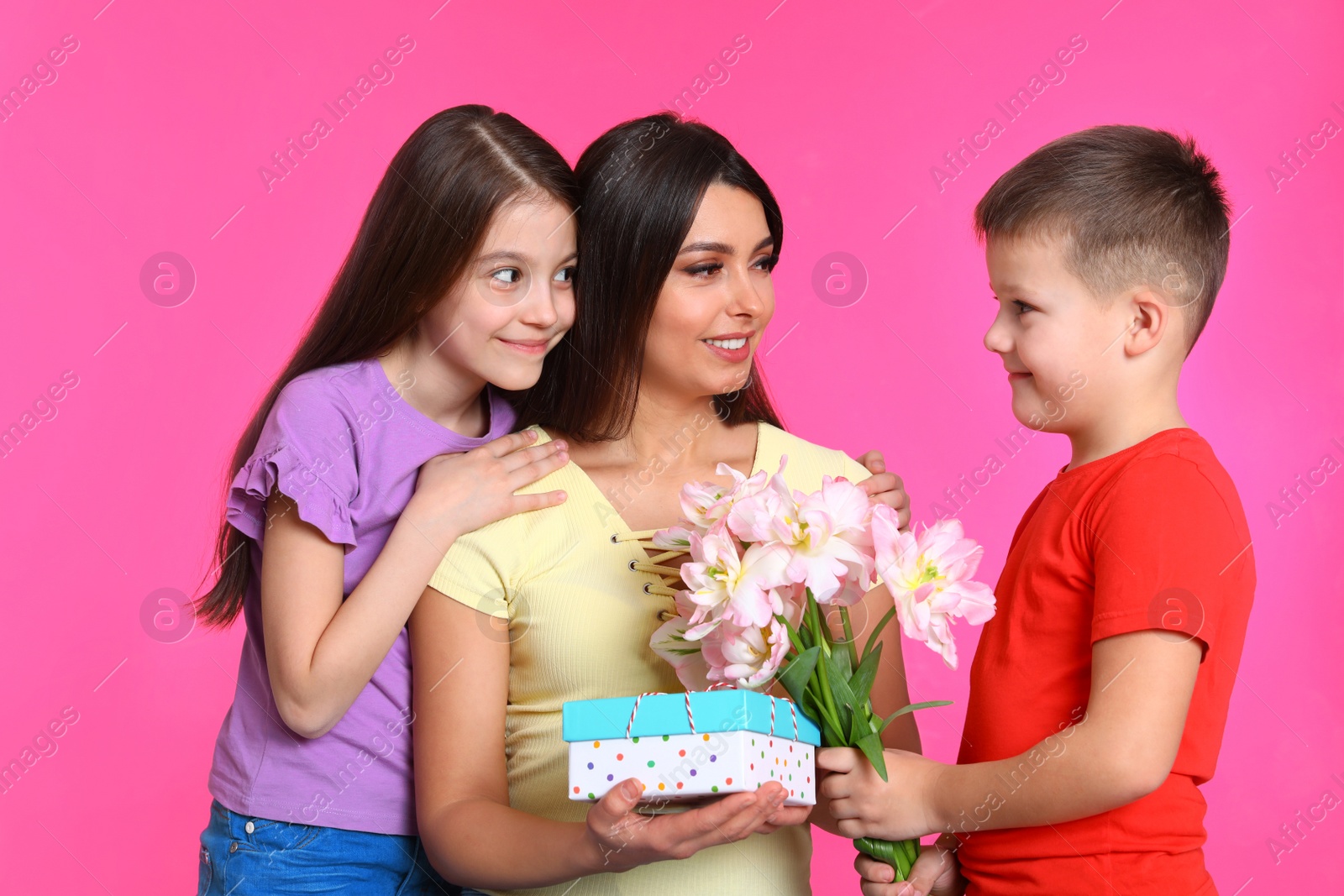 Photo of Son and daughter congratulating mom on color background. Happy Mother's Day