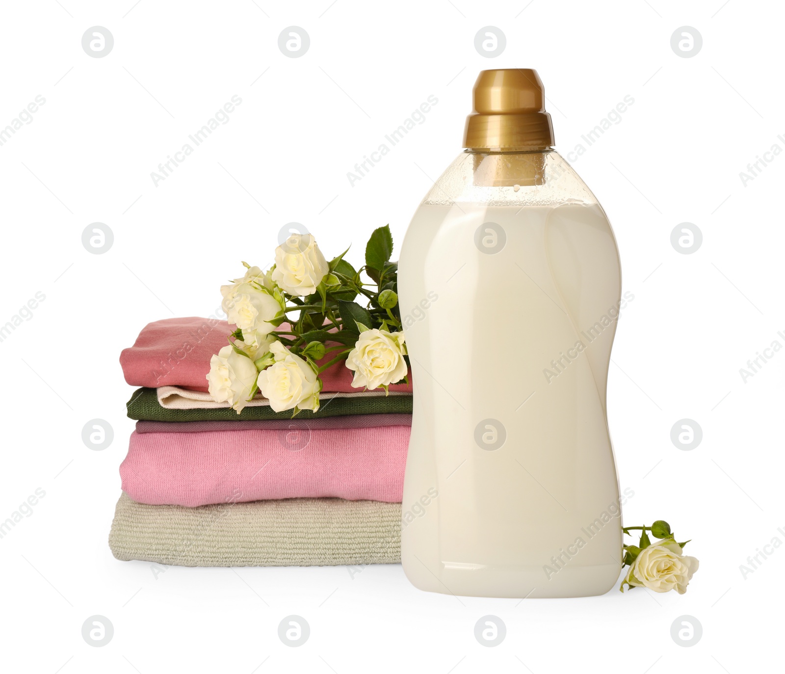 Photo of Bottle of fabric softener, stacked clean clothes and beautiful flowers isolated on white