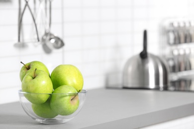 Bowl of fresh green apples on kitchen counter. Space for text